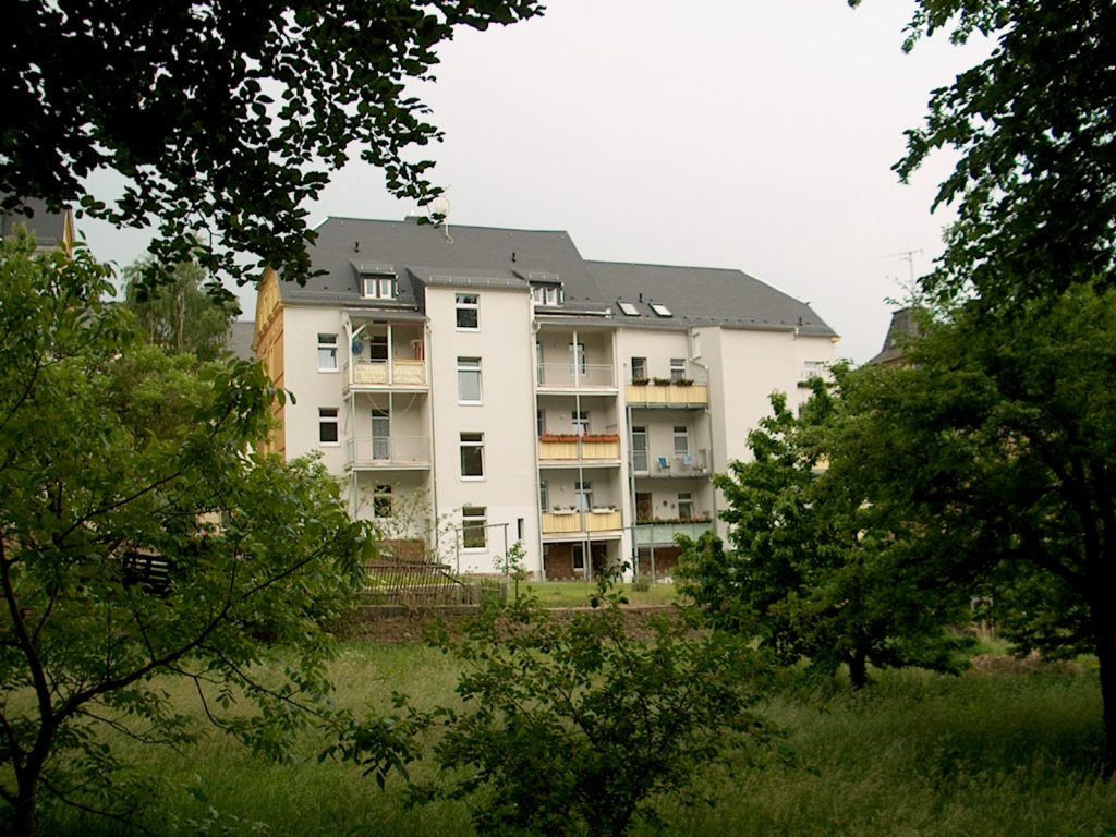 Grüner Innenhof und Balkone eines Fundament-Hauses in Waldheim